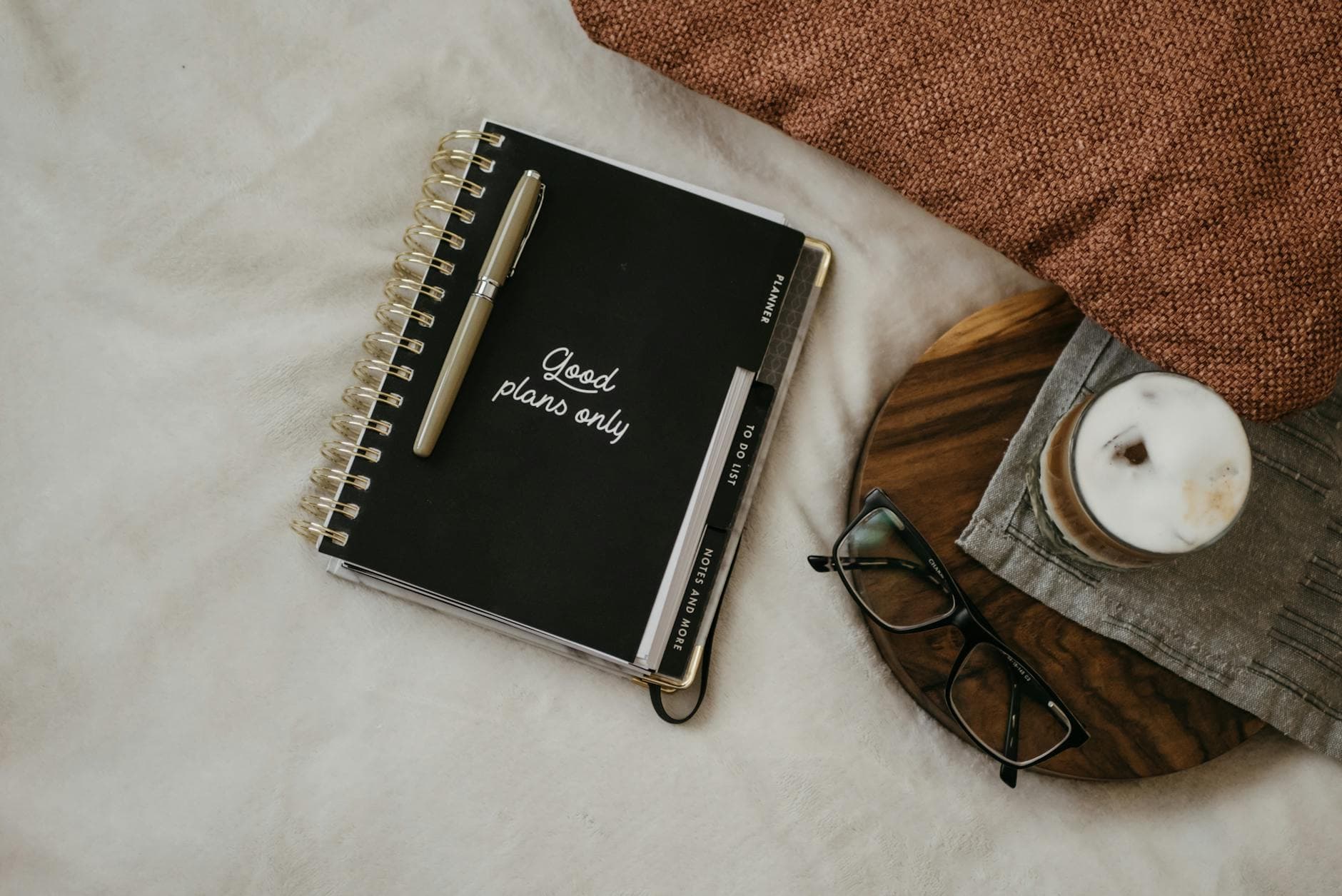 Open weekly planner beside a coffee mug and pen — quiet morning planning before a real estate prospecting session