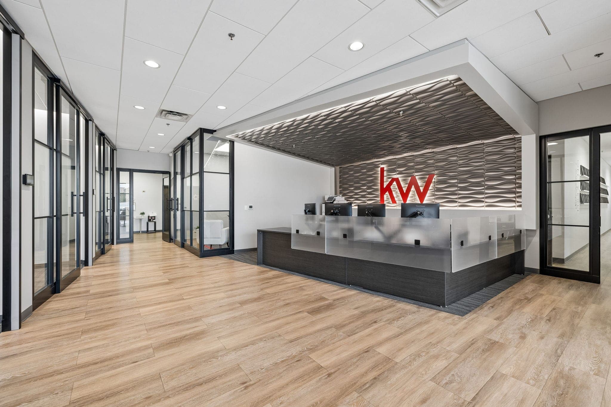 The reception desk and lit KW wall inside Keller Williams Franklin