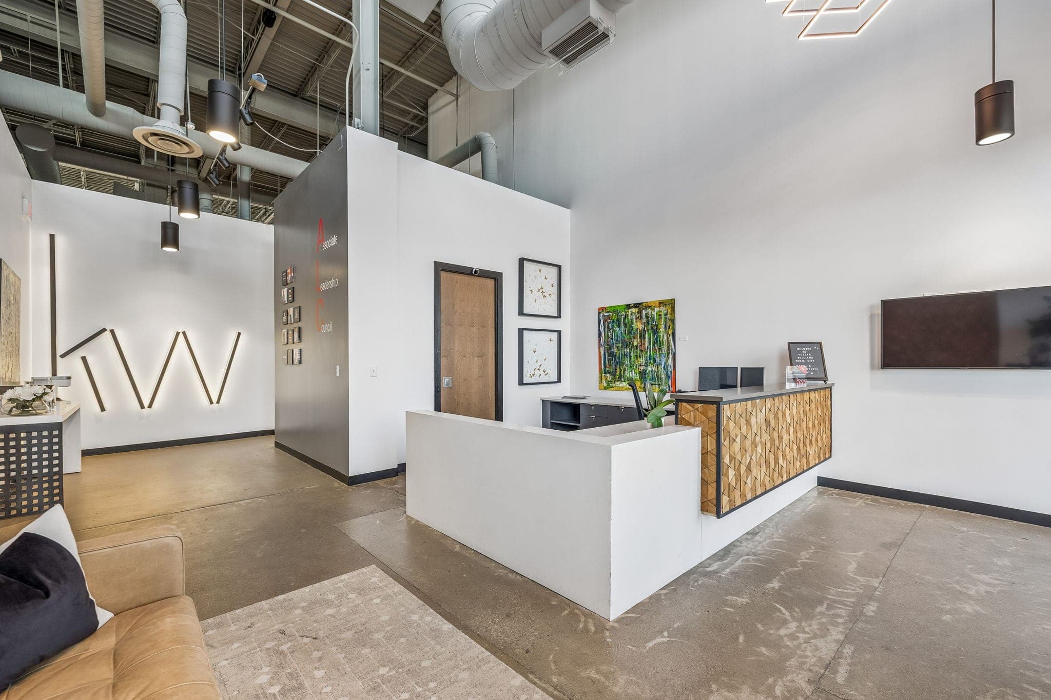The wood-front reception desk and leadership council display inside Keller Williams Nashville Music City